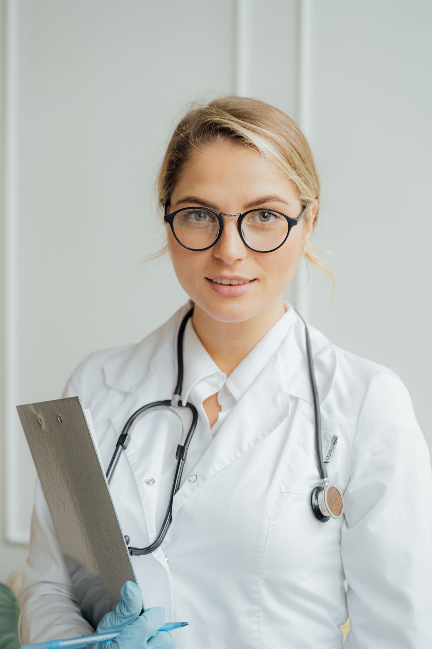 Clinician in a white coat holding a clipboard.